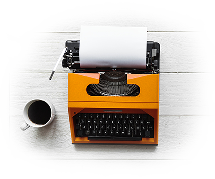 Orangefarbene Schreibmaschine, daneben eine Kaffeetasse