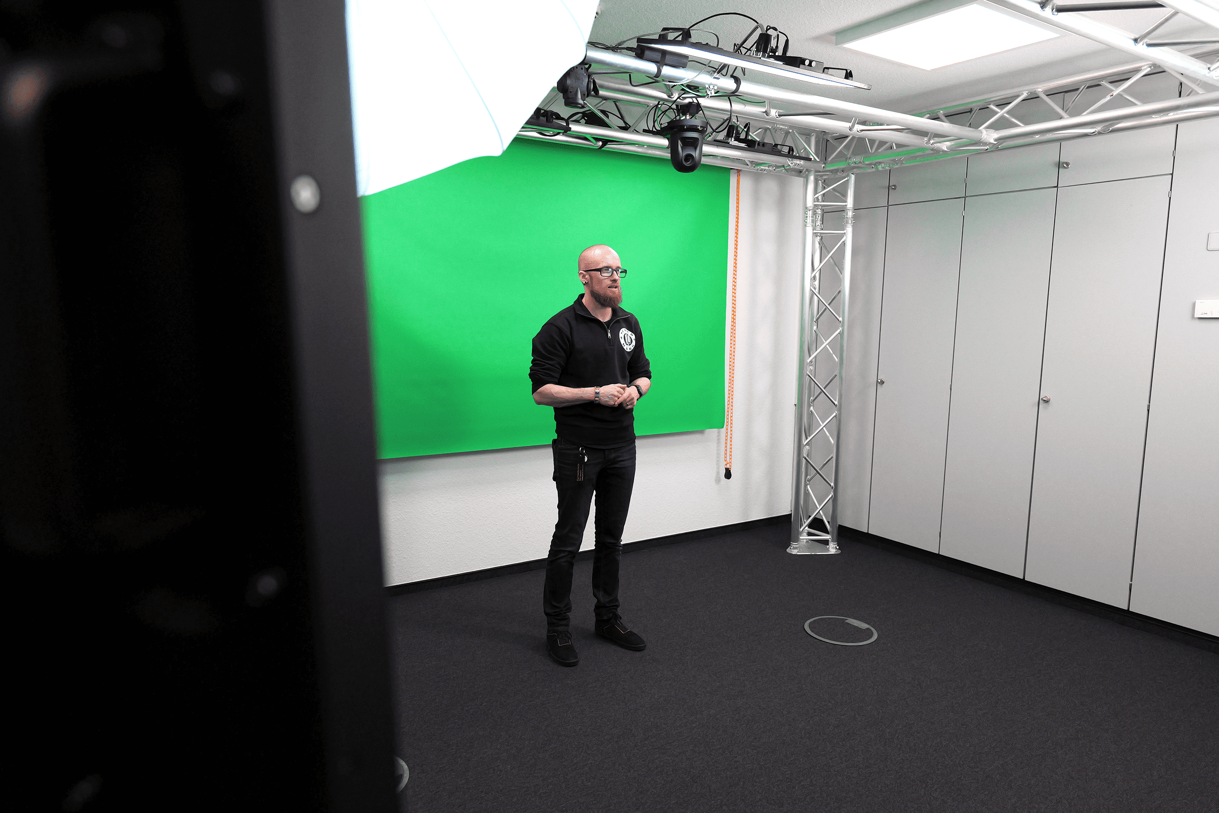 Vincent Beringhoff steht im Studioraum des Videolabors vor einem Greenscreen
