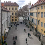 Der Platz vor dem Schlossberg in Graz. Ein paar Menschen sind zu sehen.