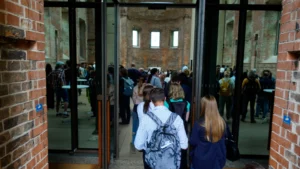 Foto: Blick in den Eingang der St. Elisabeth Kirche, zu sehen sind Personen, die gerade hineingehen und das Innere der Kirche.