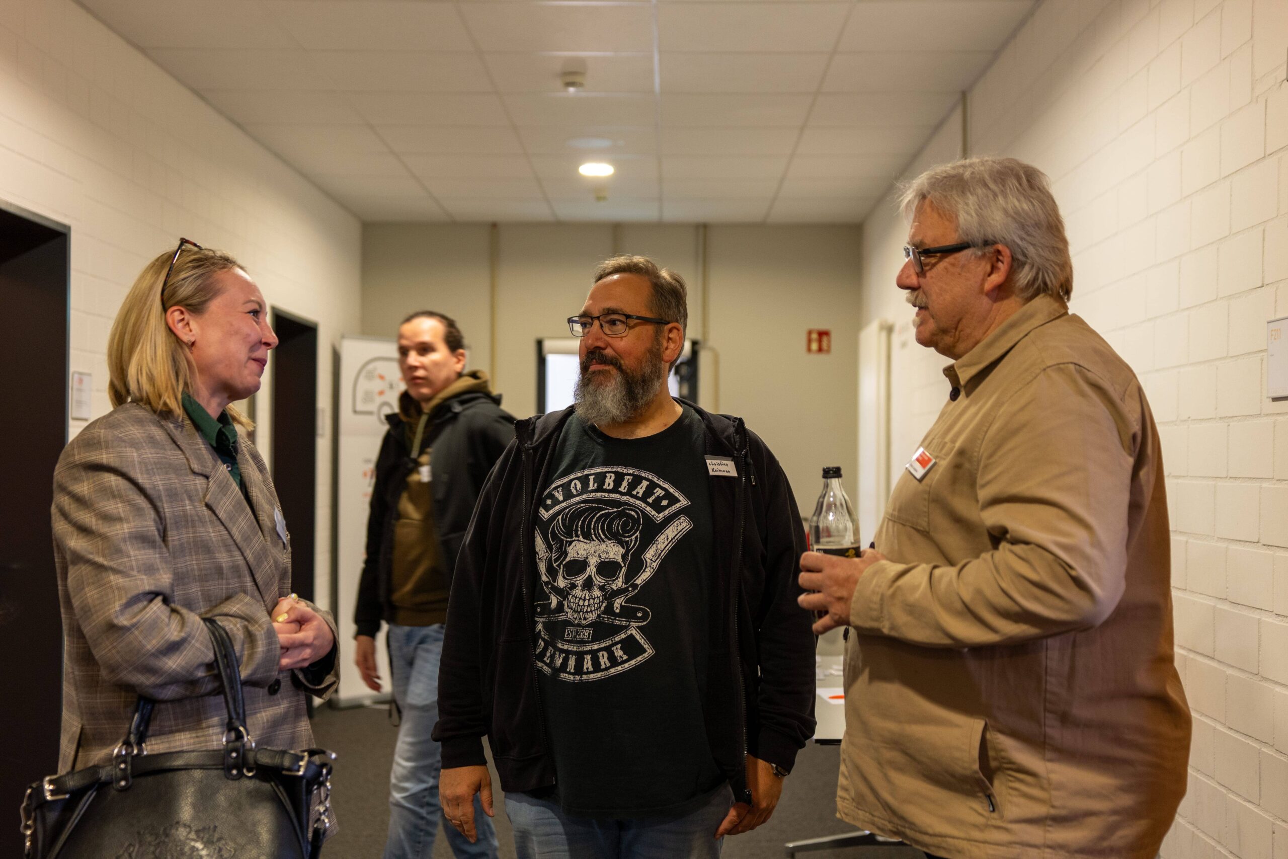 Foto: Drei Personen stehend im Gespräch